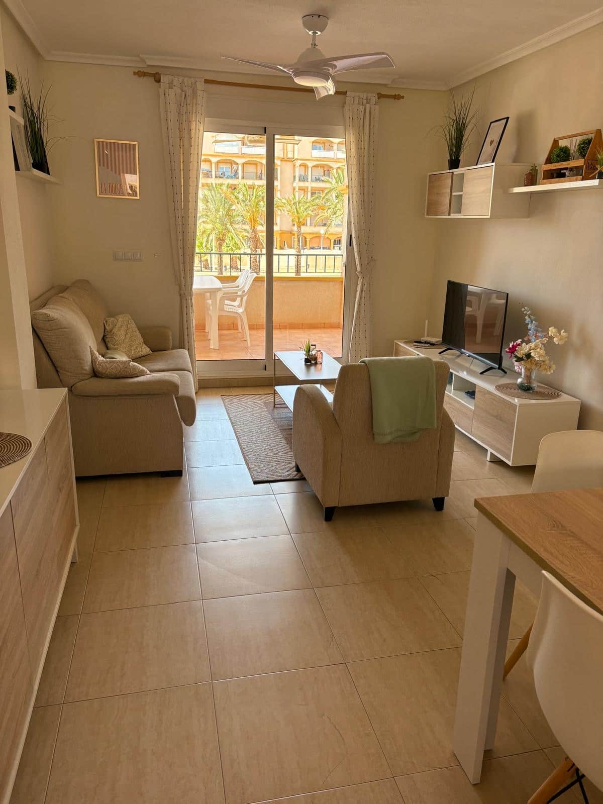 Woonkamer van Cheyu met balkon en palmbomen buiten